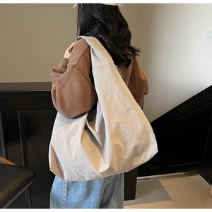Detail view showing the relaxed drape and large capacity of this beige minimalist tote bag