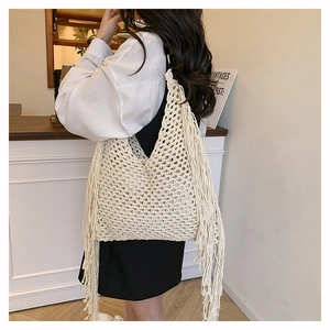 Detailed view of cream crochet tote bag featuring handcrafted mesh and long side tassels