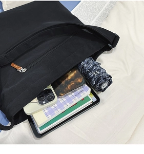 Detailansicht des geräumigen Innenraums eines schwarzen Shoppers mit Tablet und Smartphone