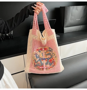 Detailed close-up of handmade crochet tote bag with dragon embroidery and frog buttons