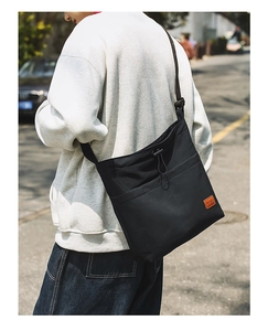 Detailaufnahme der schwarzen Nylon-Tasche mit Kordelzugtasche und breitem Gurt