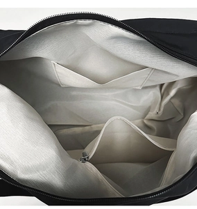 Macro view of the bag's gray interior lining featuring zipper and slip pockets