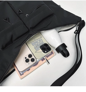 Close-up of black water-resistant nylon shoulder bag with multiple compartments and capacity