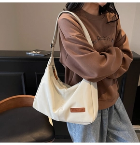 Model showcasing cream large tote bag with brown leather details for casual daily use