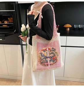 Détail d'un sac cabas au crochet avec broderie de dragon et boutons chinois traditionnels