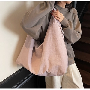 Close-up of light purple nylon tote bag showing pleated texture and large capacity