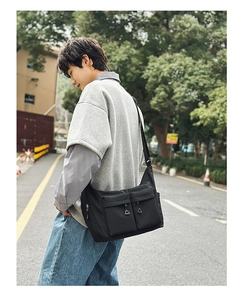 Detail shot of the black water-resistant nylon messenger bag with multiple zipper pockets