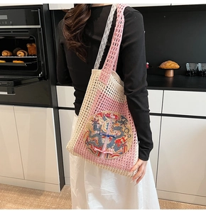 Gros plan sur le sac fourre-tout en tricot rose et beige avec broderie dragon chinois