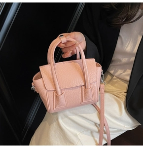 Detailed macro view of pink lychee pattern faux leather on a stylish mini top-handle bag