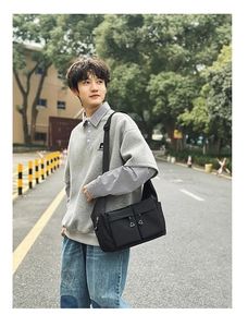 Waterproof nylon crossbody bag with large front pockets shown in a street style setting