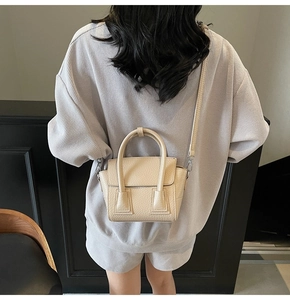 Close-up of beige lychee texture mini crossbody bag on model showing size and scale