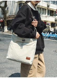 Detail der weißen Nylon-Einkaufstasche mit Kordelzug und Fronttasche am lässigen Modell