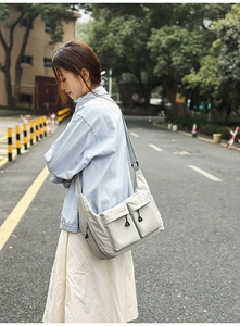 Detailed view of light grey water-resistant nylon utility shoulder bag with snap pockets
