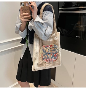 Detail of hollow woven tote bag featuring a traditional Chinese dragon embroidery patch
