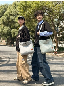 Outdoor-Aufnahme von zwei Models mit großen Nylon-Tote-Bags in Beige und Grau