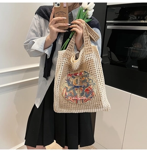 Détail d'un sac cabas tissé avec broderie de dragon et fermoir traditionnel chinois