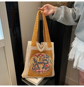 Détail du sac cabas tissé avec motif au crochet jaune et broderie de dragon
