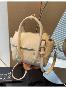 Beige lychee textured leather crossbody bag with top handles and adjustable shoulder strap