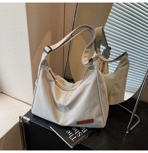 Detail view of large nylon hobo bag featuring adjustable strap and premium leather brand logo