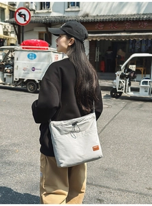 Detailansicht graue Nylon-Einkaufstasche mit Kordelzugtasche und Leder-Logo-Patch
