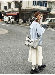 Close-up of light grey water-resistant nylon crossbody bag with dual front utility pockets