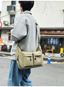 Detail of water-resistant nylon messenger bag with functional side zippers and pockets