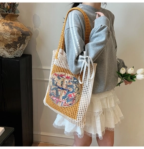 Détail du sac cabas tissé avec broderie de dragon bleu et nœuds décoratifs colorés