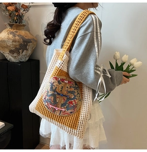 Détail du sac cabas tissé avec broderie de dragon chinois et design en maille ajourée