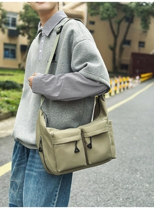 Detail of waterproof olive green nylon shoulder bag with dual functional front pockets