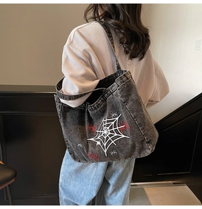Detailansicht der Jeans-Tasche mit Spinnennetz-Stickerei und roten Spinnen-Aufnähern
