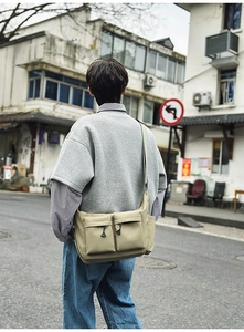 Detailed view of water-resistant nylon messenger bag with functional front zip pockets