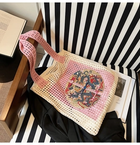 Détail du sac cabas tissé rose et blanc avec broderie de totem de dragon sur le devant