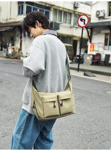 Detail of water-resistant nylon messenger bag with double flap pockets and adjustable strap