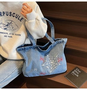 Detaillierte Stickerei von weißen Spinnennetzen und roten Spinnen auf blauer Jeans-Tote
