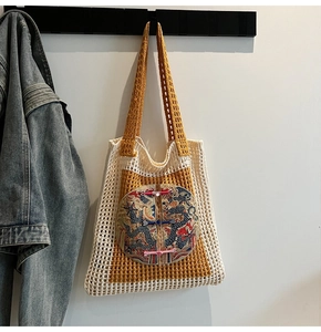Détail d'un sac cabas tissé avec broderie de dragon et boutons traditionnels