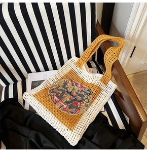 Gros plan sur le sac fourre-tout tissé beige et jaune avec détail de dragon brodé