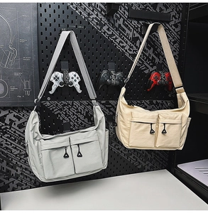 Macro detail of waterproof nylon crossbody bags with dual pockets and adjustable straps