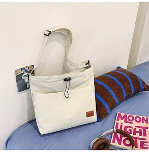 Detail der cremefarbenen Canvas-Tasche mit Kordelzug und verstellbarem Schultergurt