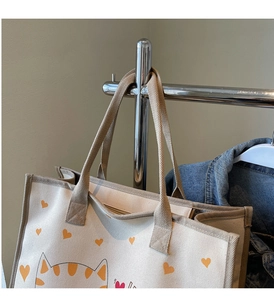 Détail du sac cabas en toile crème avec motif cœur jaune et chat avec fermeture zippée