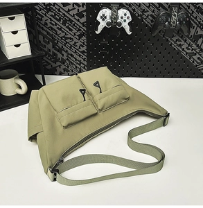 Detail of waterproof olive nylon bag featuring dual front pockets and adjustable strap
