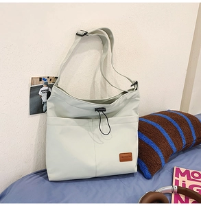Detailansicht einer großen Nylon-Tragetasche mit praktischen Vordertaschen und Markenlogo