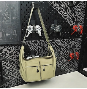 Detail of water-resistant nylon shoulder bag with dual zipper pockets and utility style