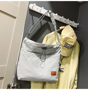 Detailaufnahme der grauen Nylontasche mit Kordelzugtasche und Leder-Logoaufnäher