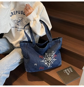Detailansicht der dunkelblauen Denim-Einkaufstasche mit Spinnennetz-Stickerei