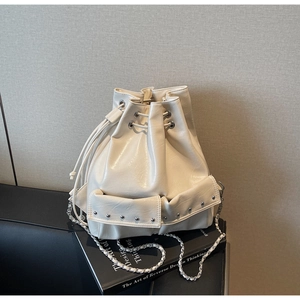 Detail of cream white bucket bag featuring drawstring closure and silver rivet pockets