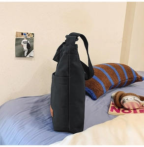 Detailansicht der Seitentasche der schwarzen Canvas-Tragetasche mit Lederpatch im Schlafzimmer