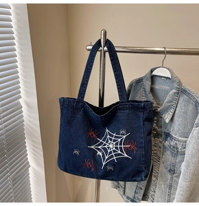 Detailansicht der dunkelblauen Denim-Einkaufstasche mit weißer Spinnennetz-Stickerei