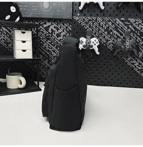 Detail view of water-resistant nylon shoulder bag side pocket in a minimalist desk setup