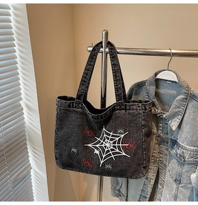 Detailaufnahme der Spinnennetz-Stickerei auf einer Vintage-Denim-Einkaufstasche