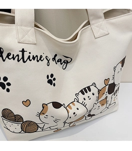 Detail of off-white canvas tote bag featuring cute cartoon cat and Valentine's Day text